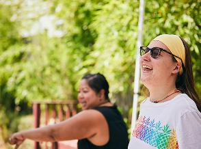 Kelley, living with TSC, outdoor with caregiver. Watch EPIDIOLEX® (cannabidiol) stories.